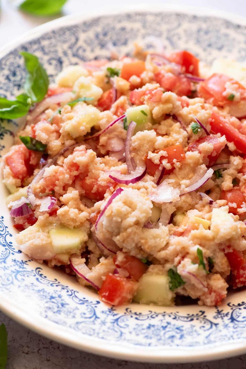 A close up of authentic Panzanella salad in a blue bowl.