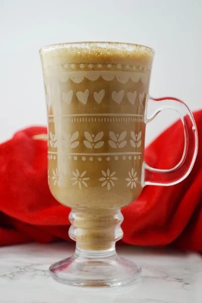 Banana milk coffee in a glass mug on a white surface