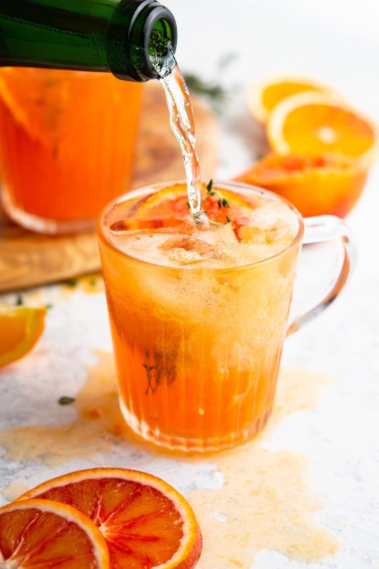 Prosecco getting poured into a blood orange cocktail