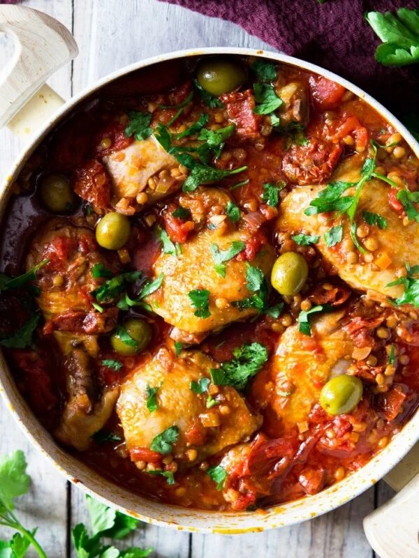 a close up of one-pot chicken with olives, tomatoes and olives