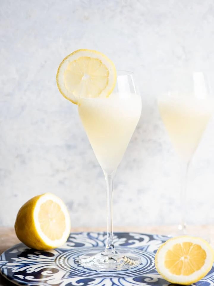 A Sgroppino cocktail in a flute glass with a slice of lemon on the side.