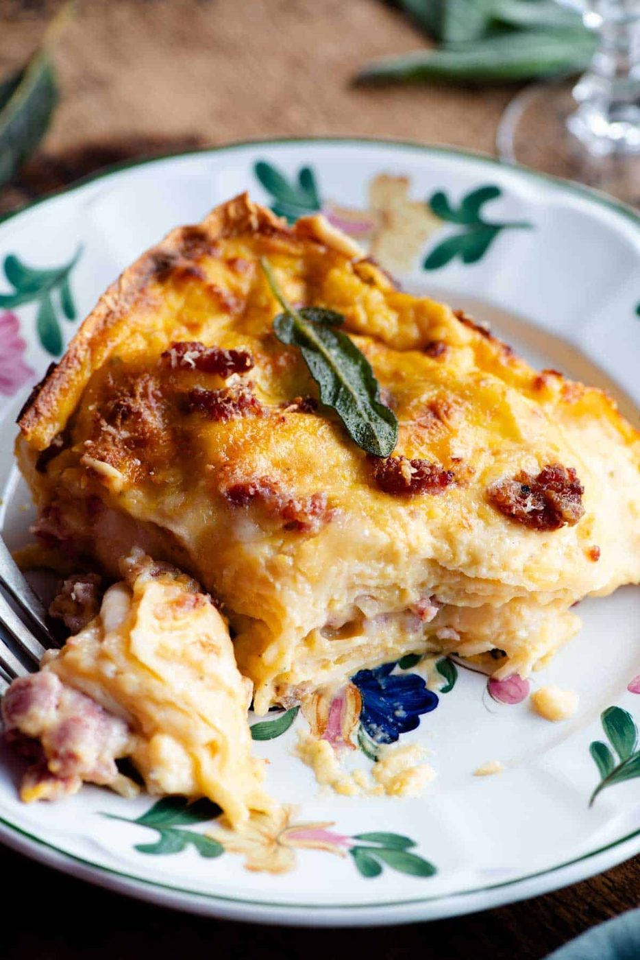 A slice of butternut squash lasagna on a floral patterned plate.