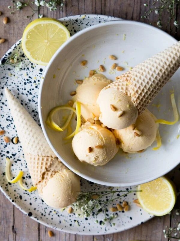 lemon ice cream scoops in a bowl garnished with lemon zest