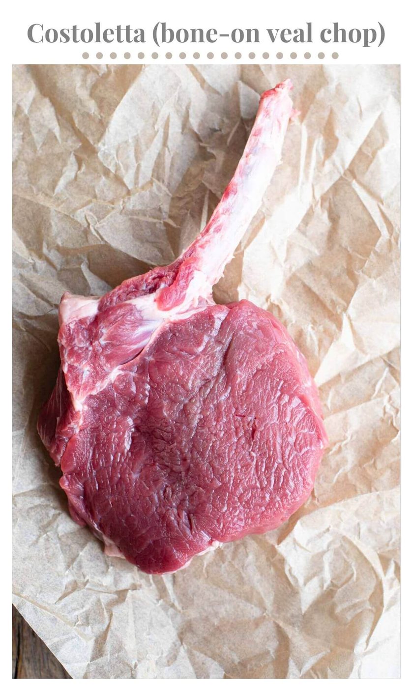 A close up of a raw veal chop with the bone still attached. 
