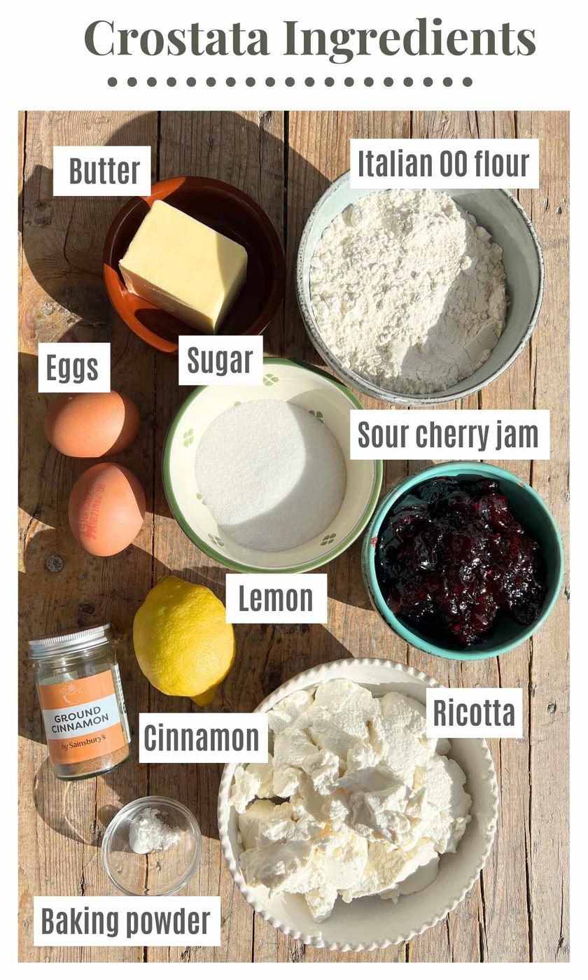 All the ingredients needed to make crostata ricotta e visciole on a wooden surface.