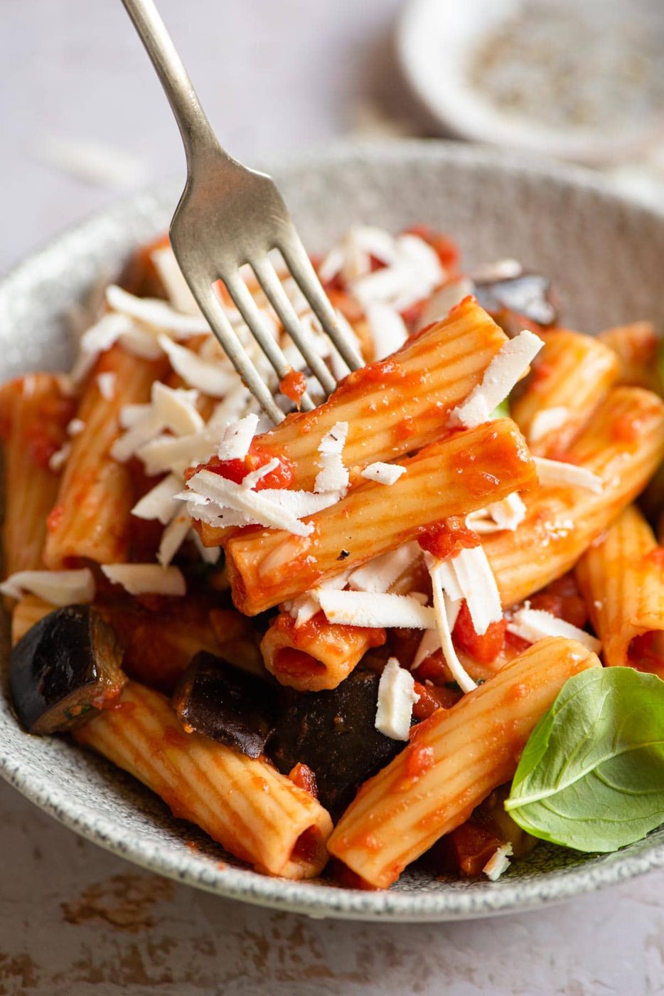 A close up of eggplant pasta on a fork