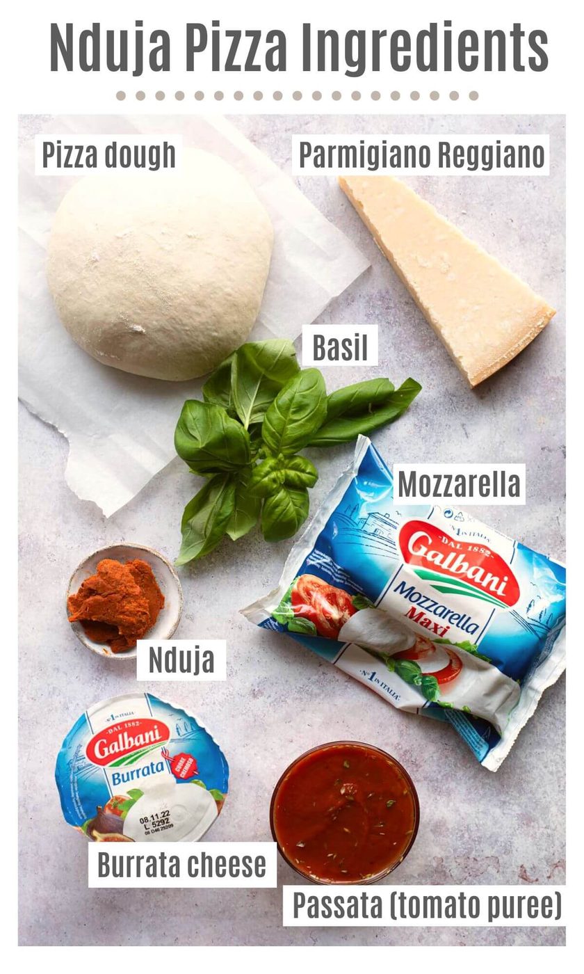 An overhead shot of ingredients to make Nduja Pizza labelled; pizza dough, Parmigiano Reggiano, basil, mozzarella, Nduja, Burrata cheese, Passata (tomato puree).