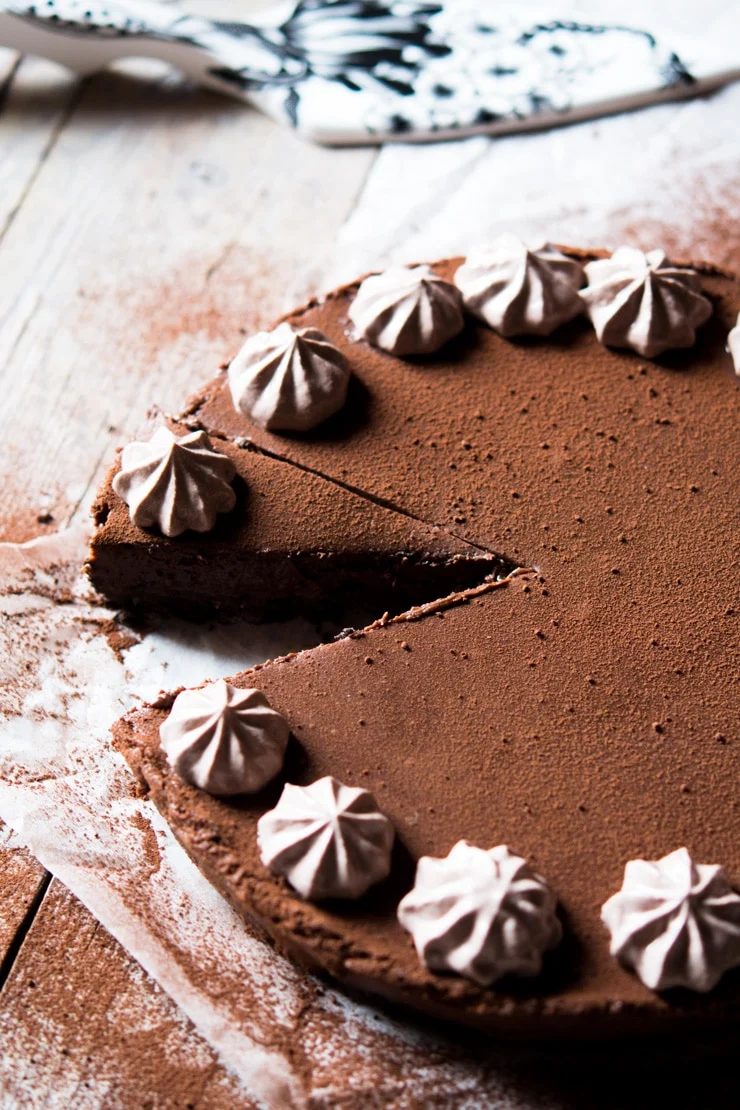 a slice of no bake chocolate cheesecake cut out and sitting on a wooden surface