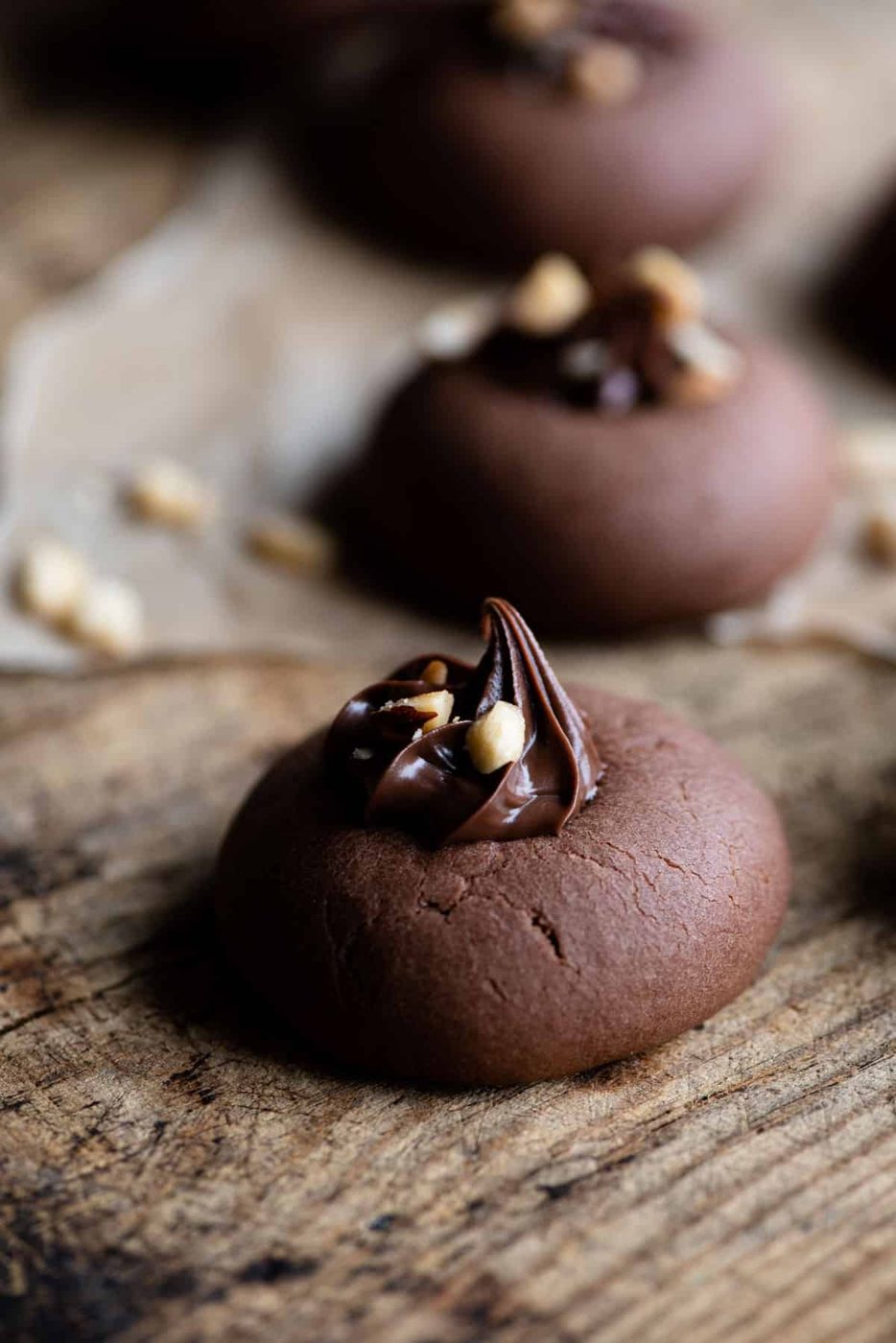 A close up side shot of a Nutella cookie topped with Nutella and hazelnuts.