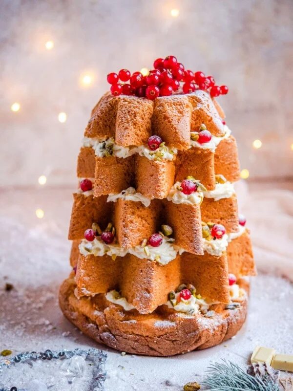 A pandoro christmas cake topped with redcurrants and nuts