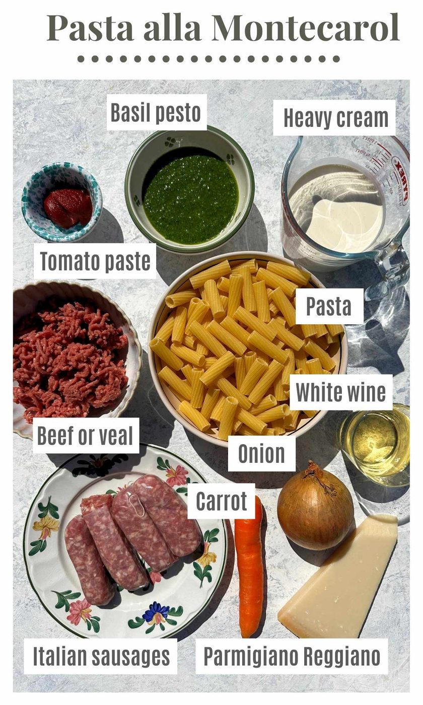 An overhead shot of all the ingredients needed to make Pasta alla Montecarlo; pesto, heavy cream, tomato paste, pasta, sausages, beef, carrot, onion, Parmesan and white wine.