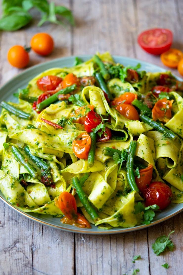 A side shot of pasta with green beans and tomatoes