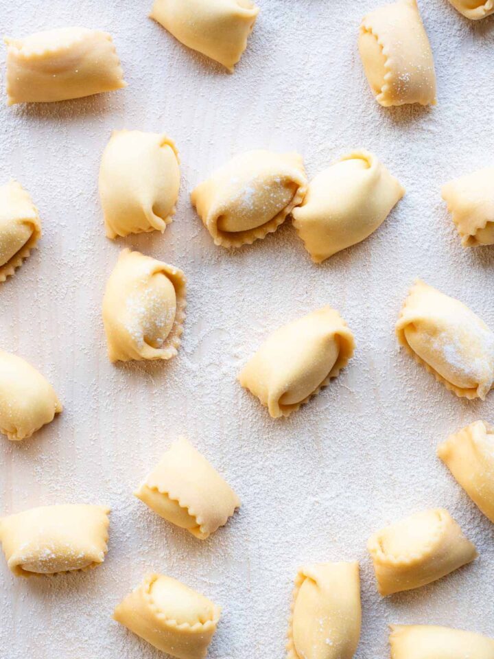 An overhead shot of Agnolotti pasta on a wooden board.