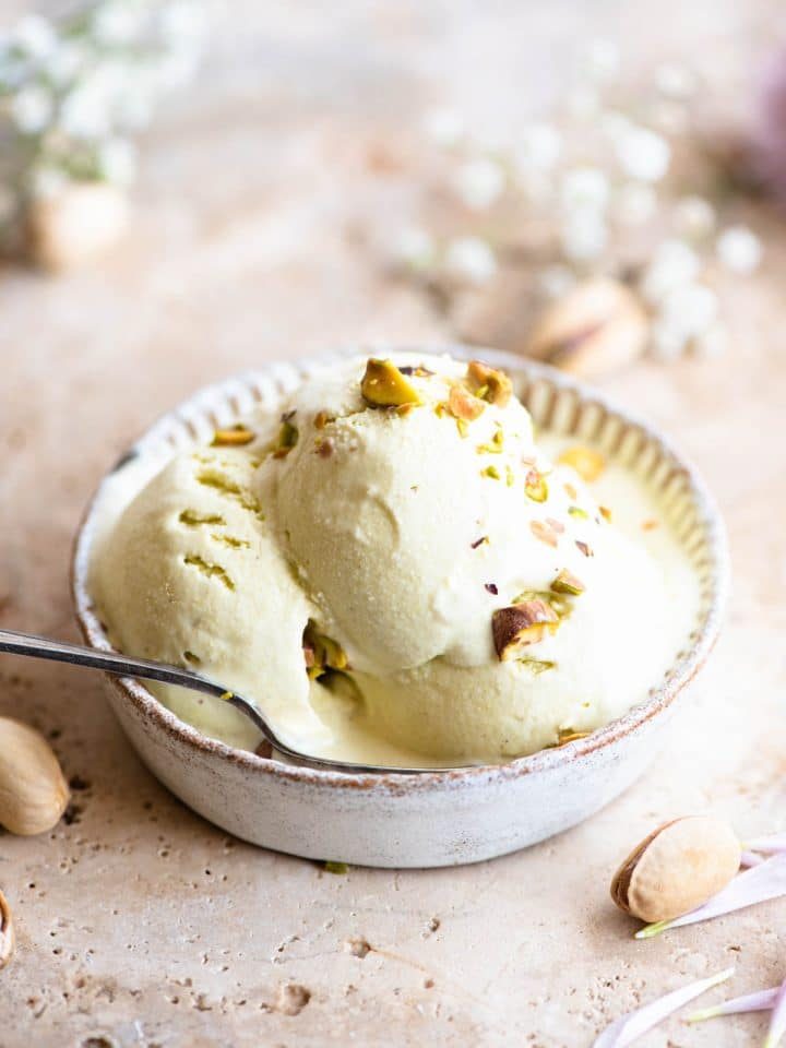 Three scoops of pistachio ice cream in a rustic looking ramekin