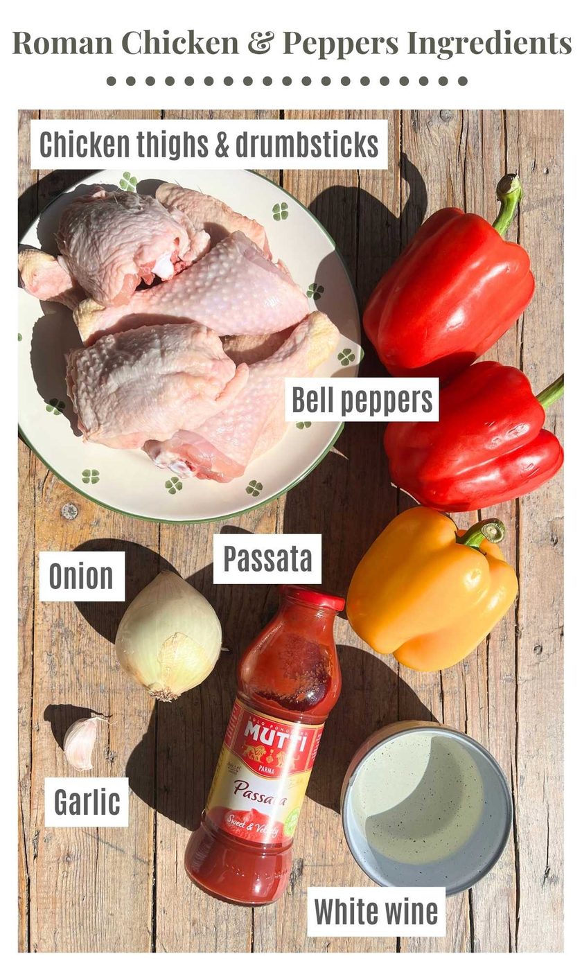 All the ingredients needed to make Roman chicken and peppers laying on a wooden surface; chicken, bell peppers, passata, white onion, garlic and white wine.
