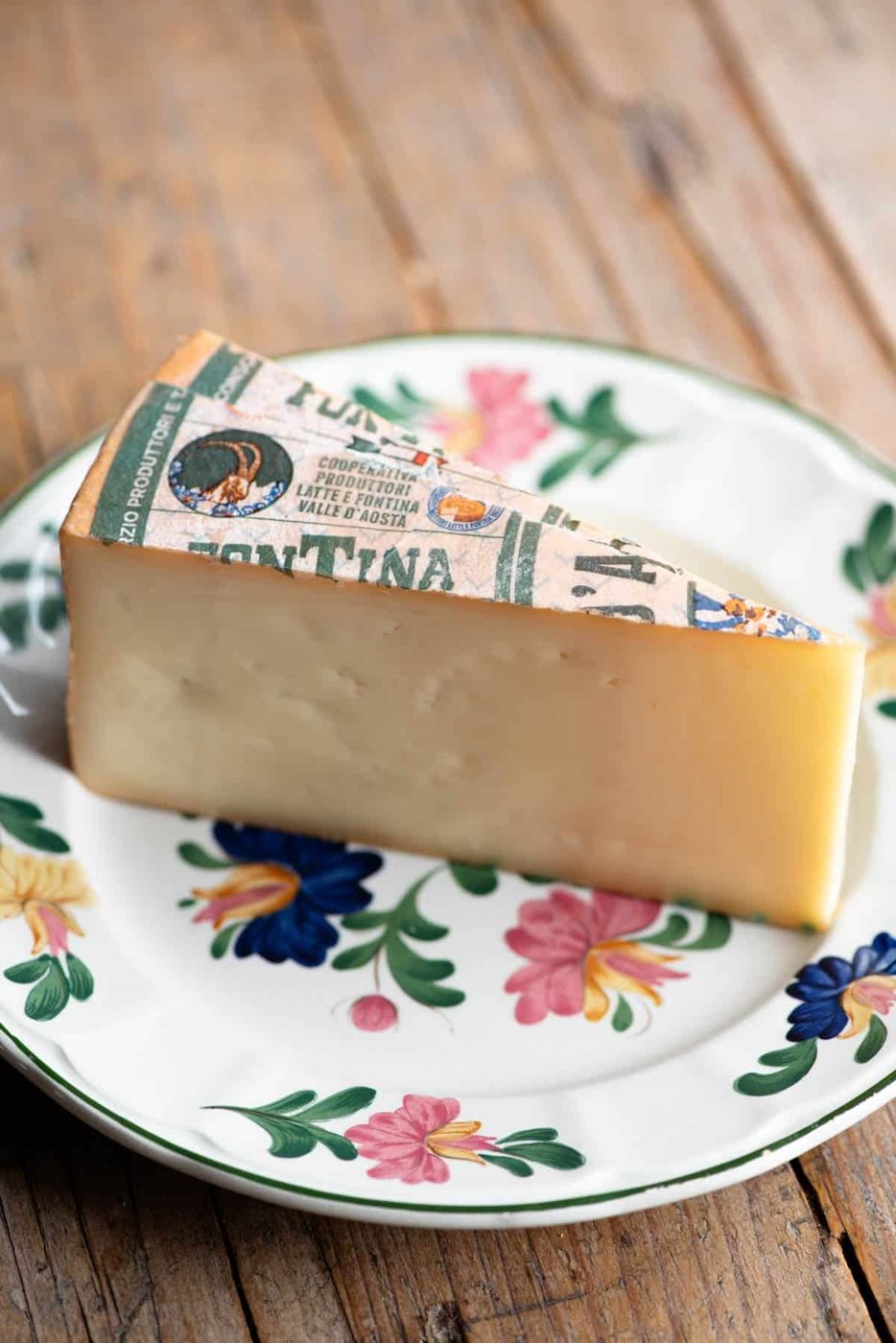 A close up of Fontina cheese on a small floral plate.