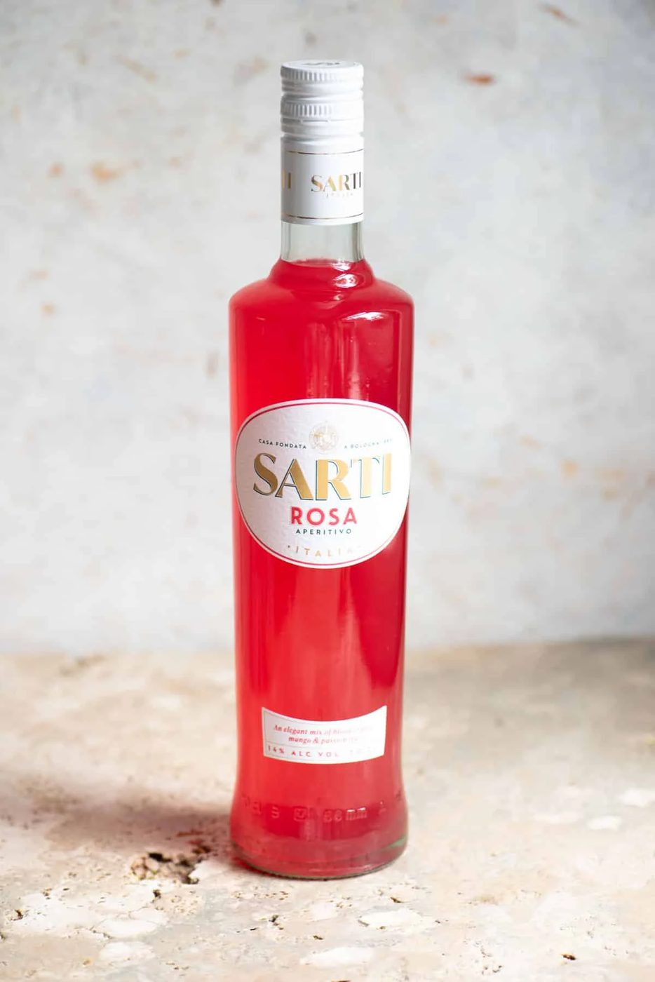 A bottle of Sarti liqueur on a neutral background.
