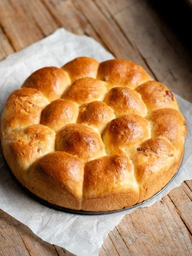 A neapolitan brioche bread (danubio salato) sitting on a rustic wooden surface.