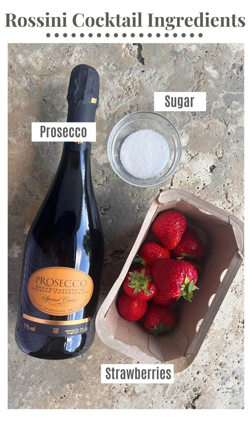 An overhead shot of a bottle of Prosecco, strawberries and sugar.