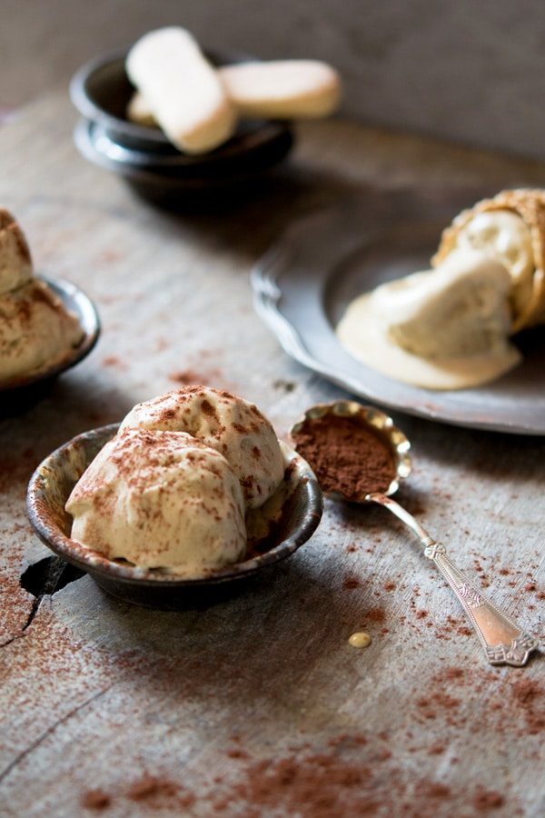 Two scoops of ice cream in a small rustic bowl