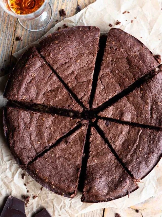 An overhead shot of an Italian flourless chocolate cake cut into slices.