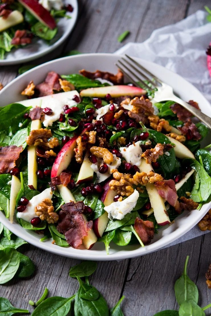 A winter salad served on a large plate on a wooden surface