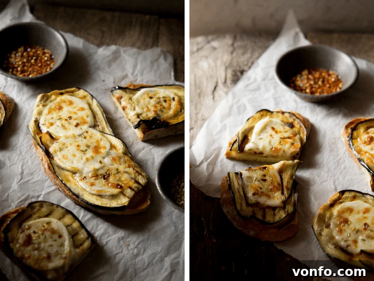 A close-up shot of grilled eggplant bruschetta with melted mozzarella, red pepper flakes, and fennel seeds, arranged on crumpled baking paper on a wooden surface.