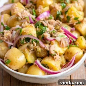 Vibrant Italian Tuna Potato Salad 6 A close up of a tuna potato salad in a bowl, ready to serve.
