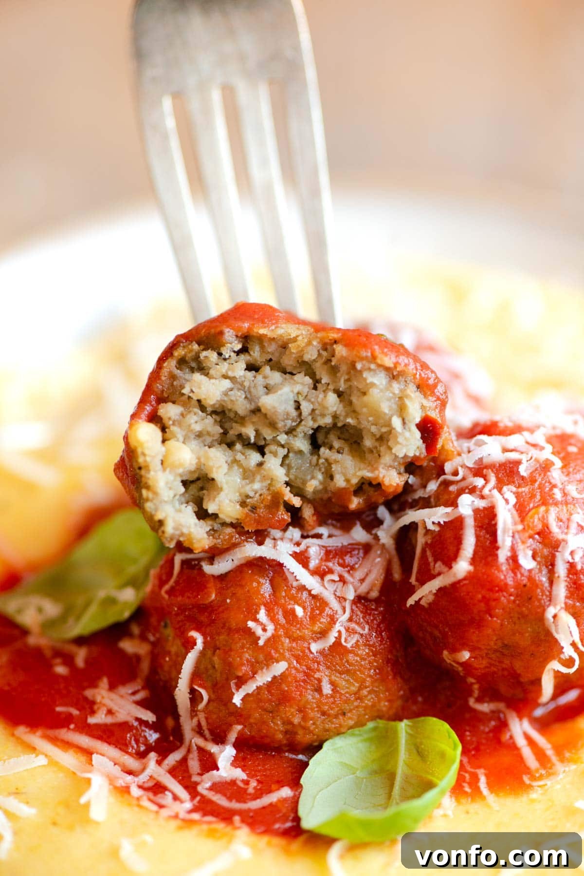 A close-up shot of a single eggplant meatball cut in half, revealing its tender, flavorful interior texture.