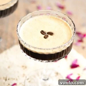 A close up of an espresso martini topped with coffee beans