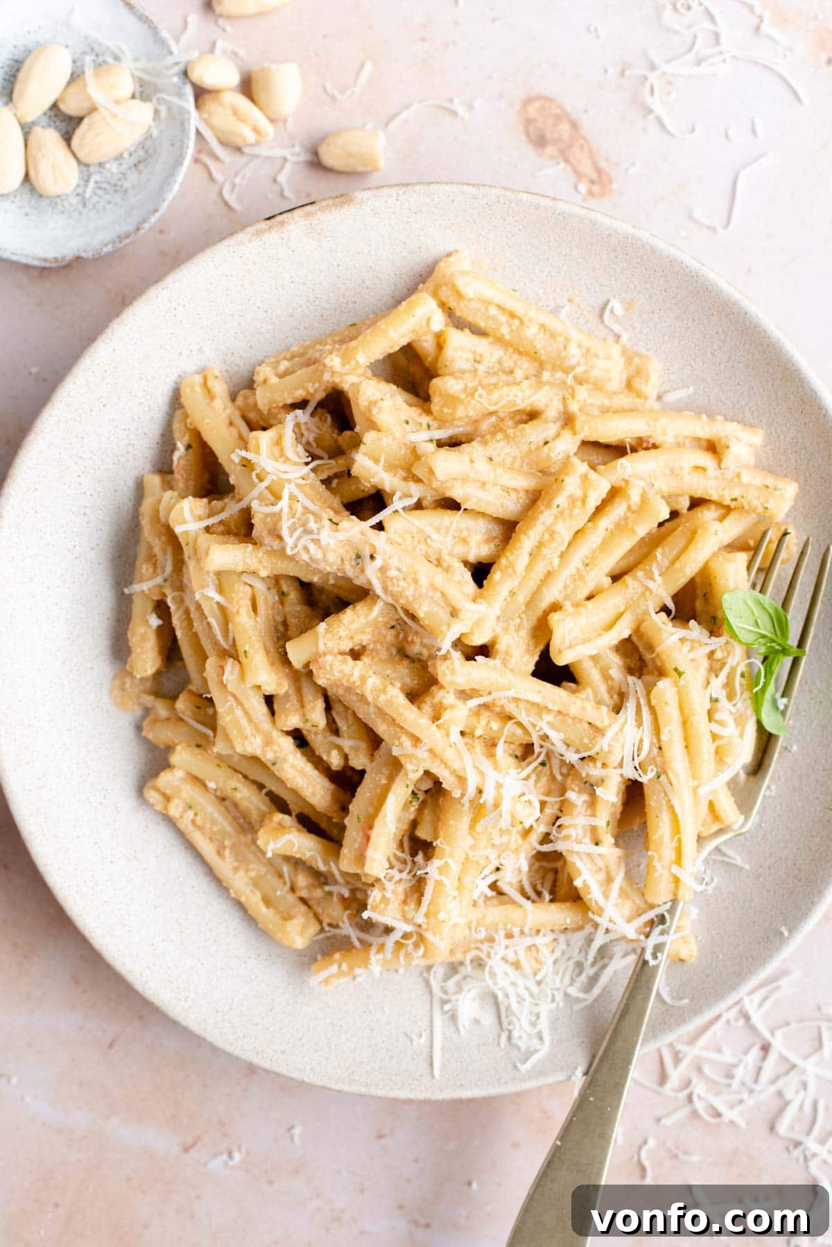 An overhead shot of pasta with pesto alla trapanese, garnished with fresh basil