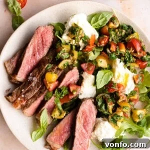 Steak tagliata on a plate with tomato and mozzarella salad
