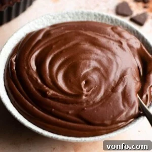 A close up of rich chocolate pastry cream in a bowl, perfectly smooth and ready to be used or served.