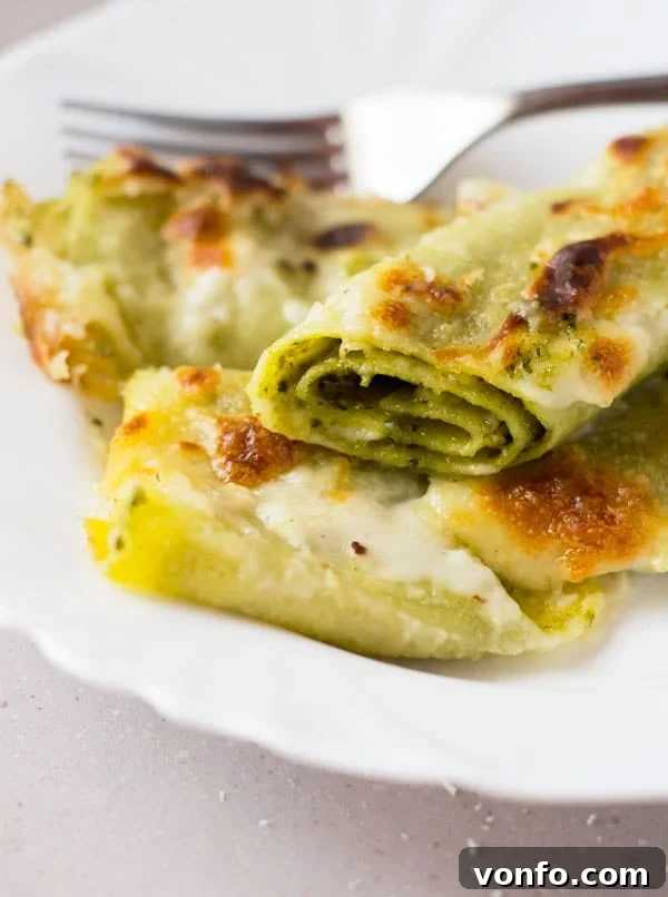 Close-up of baked Pesto Provolone Cannelloni Pasta in a baking dish