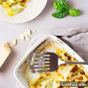 Homemade basil pesto is spread over fresh cannelloni pasta recipe and baked in a luscious cheesy provolone bechamel sauce and topped with mozzarella cheese