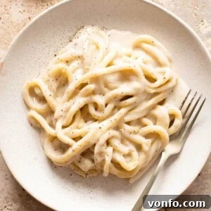 Pici Cacio e Pepe Simple Roman Perfection 7 A close up of cacio e pepe with pici pasta on a plate with a fork