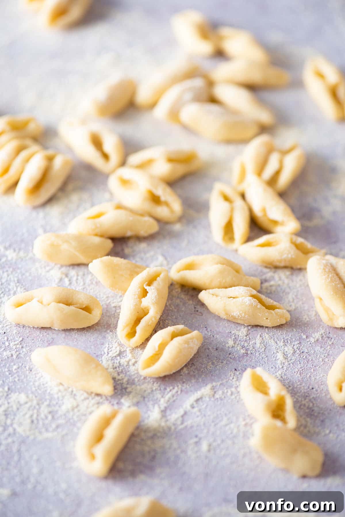 Freshly made cavatelli pasta resting on a lightly floured wooden surface, ready for cooking.