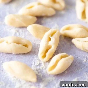A close-up of fresh cavatelli pasta on a blue work surface, illustrating the final shaped product.
