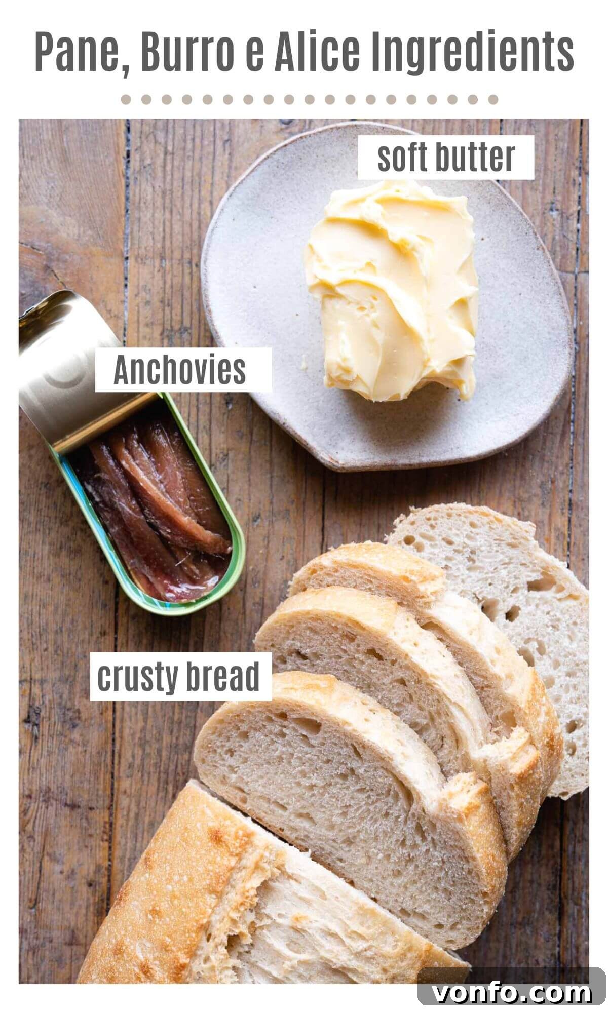 An overhead shot showing high-quality crusty bread, a block of butter, and a jar of anchovies, the essential ingredients for Pane, Burro e Alice
