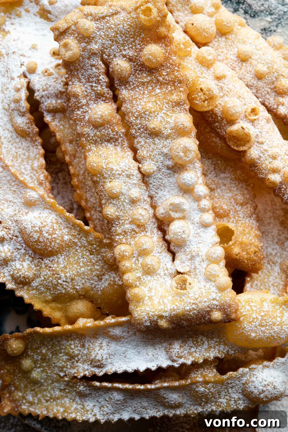 Cenci Italian Carnival Fritters 8 A close up of an Italian fried pastry dusted in powdered sugar