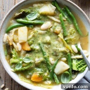 Taste of Liguria Fresh Pesto Minestrone 8 A close up of Ligurian minestrone soup in a bowl with pesto on top