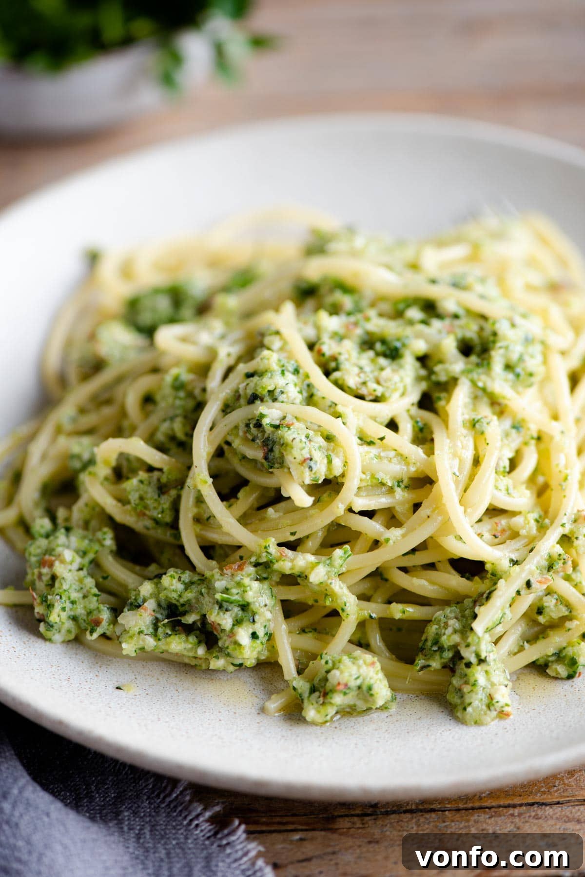 Garden Fresh Zucchini Pesto Pasta Simple and Satisfying 6 A close-up shot of individual strands of spaghetti coated in vibrant zucchini pesto, served on a white plate.