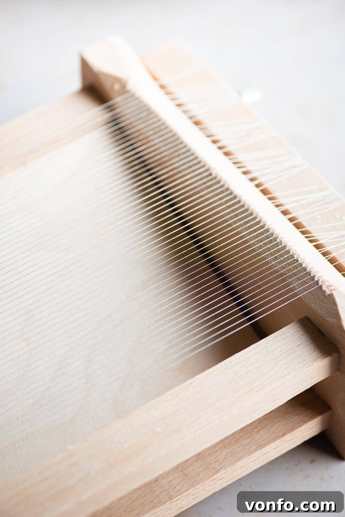 Fresh Tonnarelli: Handcrafted Chitarra Pasta 4 A close up of La Chitarra (guitar) pasta tool, showing its wooden frame and metal strings.