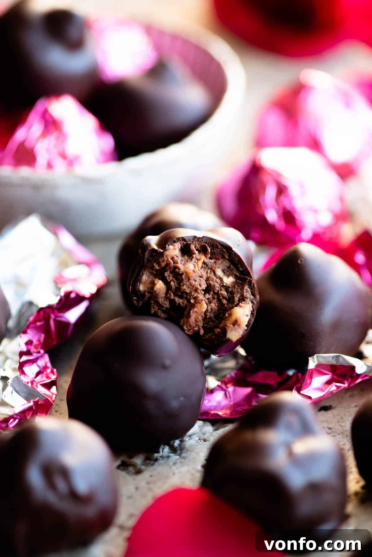 Handcrafted Italian Chocolate Kisses 4 A mesmerizing close-up of a homemade Italian hazelnut chocolate bitten cleanly in half, vividly revealing its creamy milk chocolate hazelnut center, perfectly nestled chopped hazelnuts, and the crunchy whole hazelnut within.
