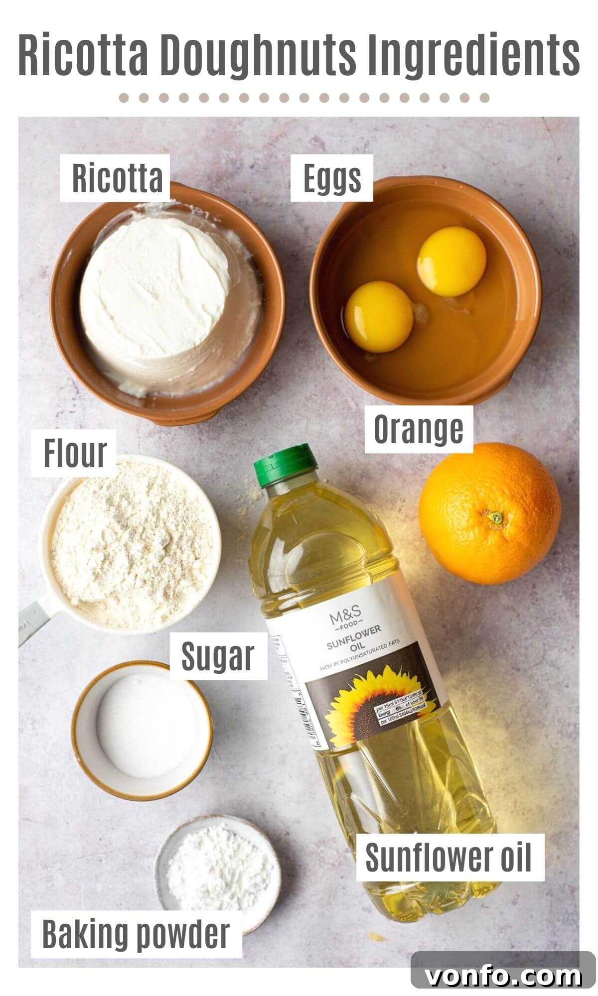 Pillowy Italian Ricotta Donuts 3 An overhead shot displaying all the fresh ingredients needed to make Italian ricotta doughnuts, including ricotta, eggs, oranges, flour, sugar, and oil.