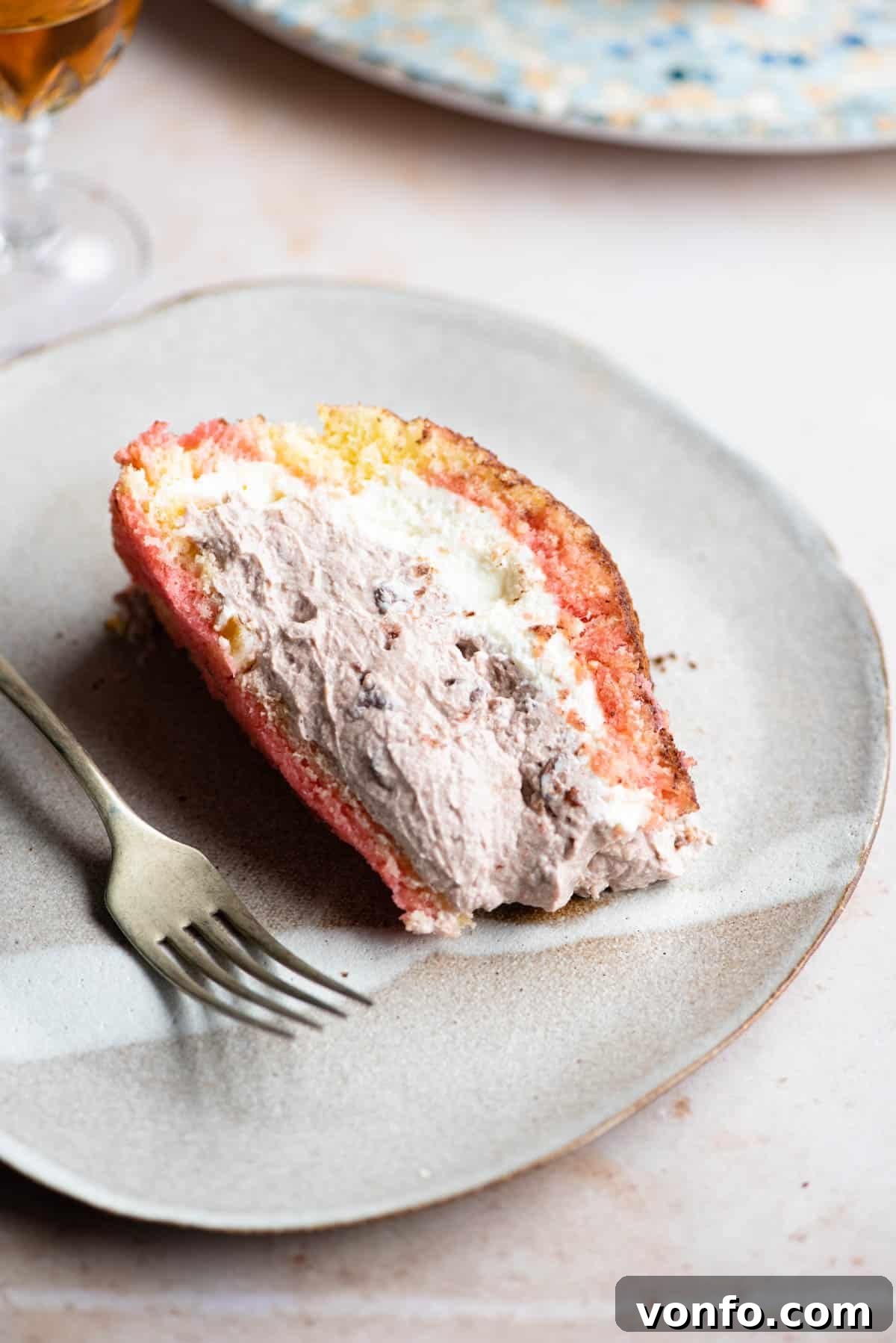 A perfectly portioned slice of Italian Zuccotto cake on a plate with a fork at the side, ready to be enjoyed.