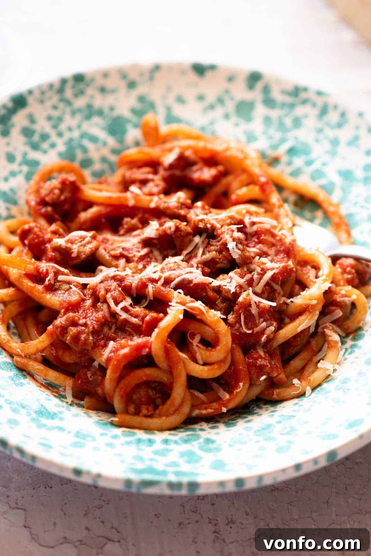 A close up of Tuscan sausage pasta in a blue bowl, highlighting the texture and sauce consistency.
