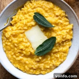 Creamy Taleggio Pumpkin Risotto, Crispy Sage Finish 9 An overhead shot of pumpkin risotto in a bowl with a slice of Taleggio cheese and crispy sage leaves on top, ready to be served.