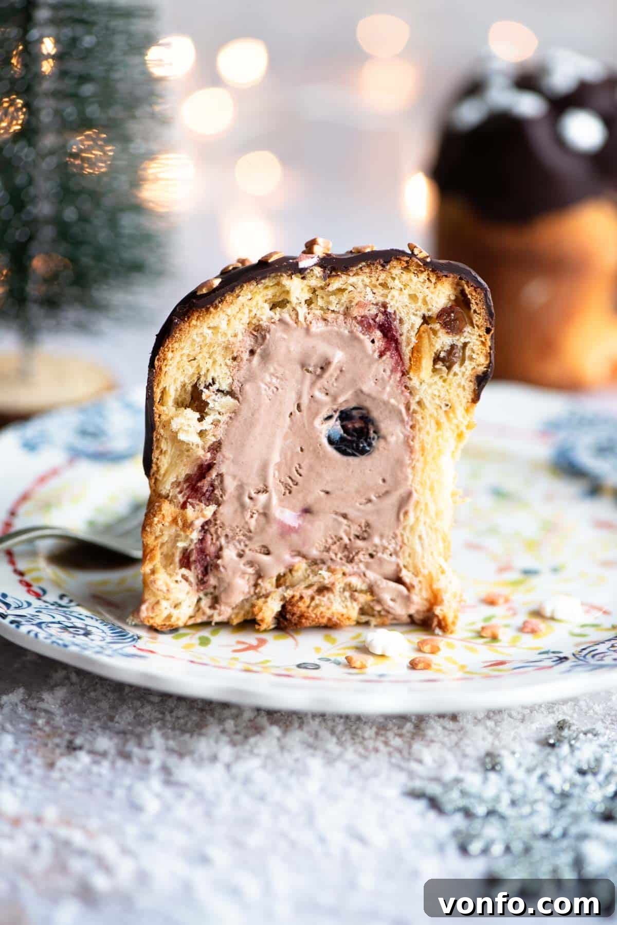 Cherry Chocolate Ice Cream Panettone Indulgence 7 A mini Panettone expertly cut in half, revealing its glorious stuffing of vibrant cherry and rich chocolate ice cream. The cross-section highlights the layers of creamy ice cream and juicy Amarena cherries, inviting a taste.