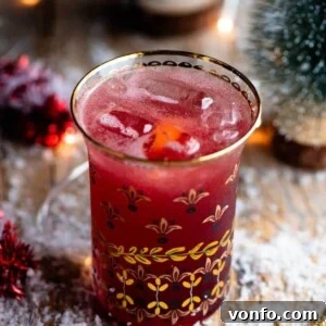 A close up of a Christmas Cocktail made of Cranberry juice and Prosecco in a gold glass.